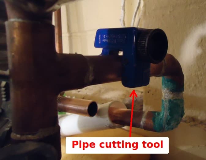 A tube cutter working through a length of copper pipe