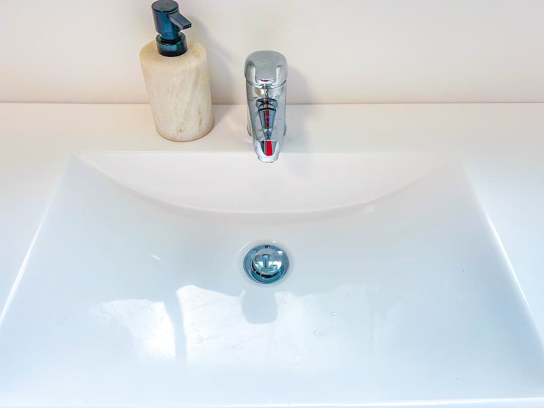 Chrome bathroom basin taps on a white ceramic sink