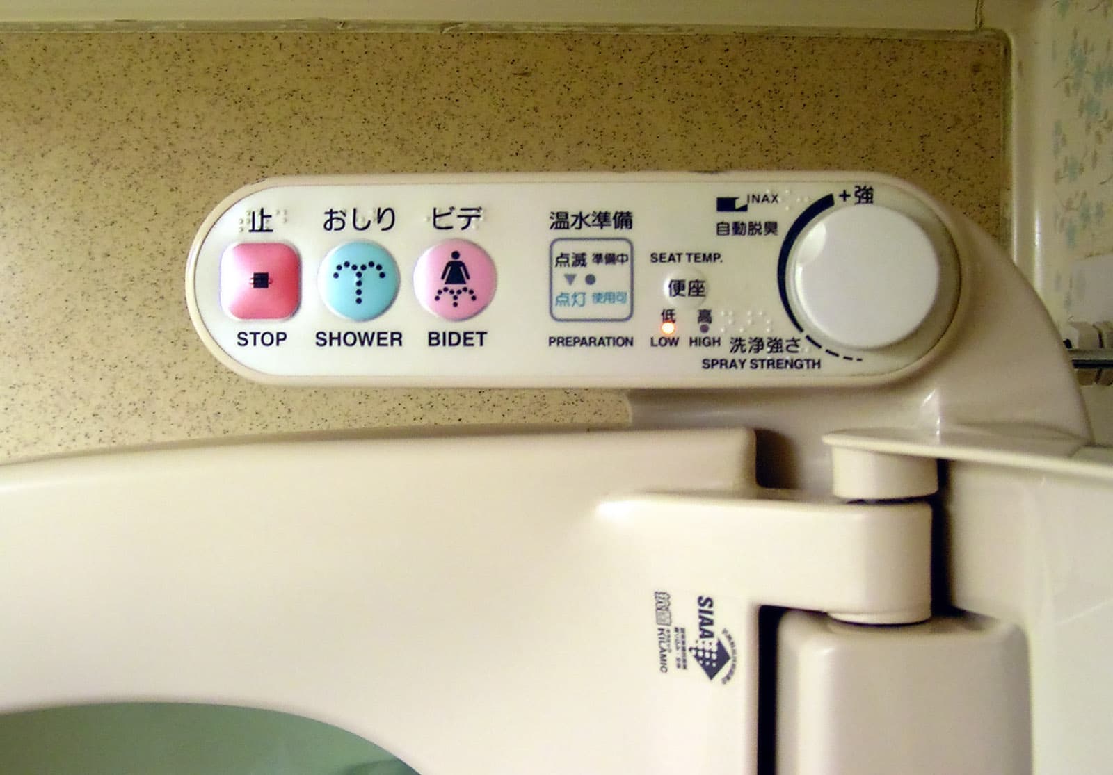 A modern Japanese toilet suite with an integrated washlet seat in a small bathroom